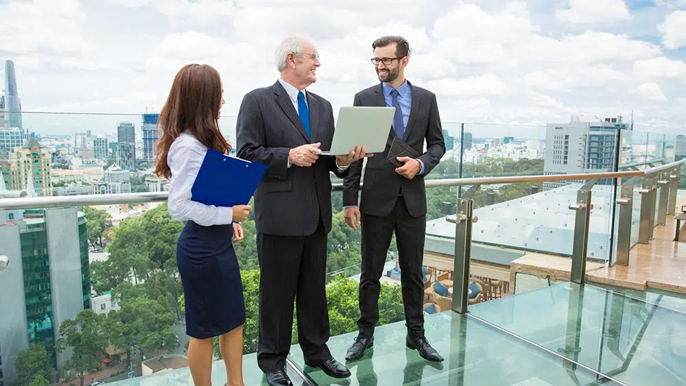 senior-business-man-with-laptop-talking-two-other-workers-to-Strengthening-Business for Long-Term Growth