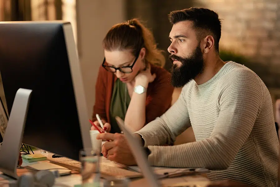 young-entrepreneur-using-computer-while-working-with-his-colleagues-office